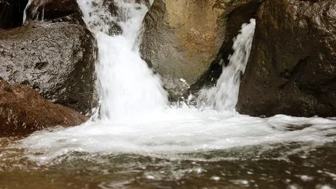 Close-up view of clear water cascading down river rocks Fotos Stock