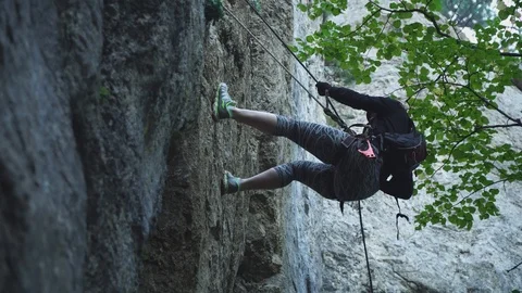 Close view climber goes down rocky cliff with safety rope Stock Footage 104188455