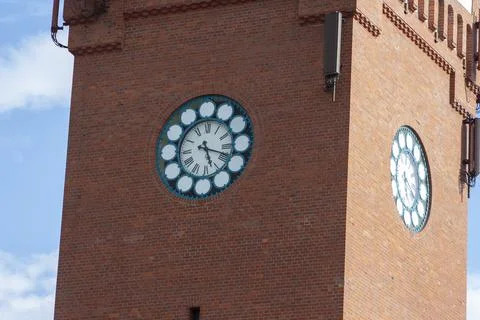 A close-up view of the clock tower with intricate designs against the blue sky. Stock Photos
