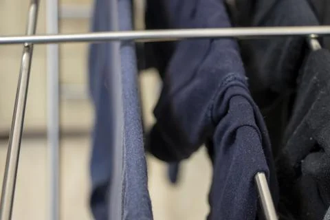 A close-up view of clothes hanging on a drying rack, showcasing various shades Stock Photos