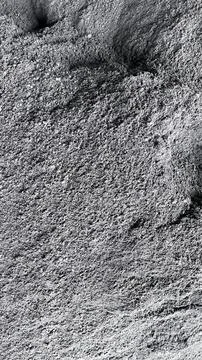 Close up view of coarse gray sand or grit with uneven surface and small shado Foto stock