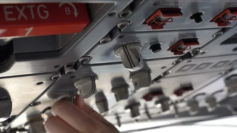 Close up view of the cockpit overhead panel of an aircraft, pilot pushing Stock Footage 106197851