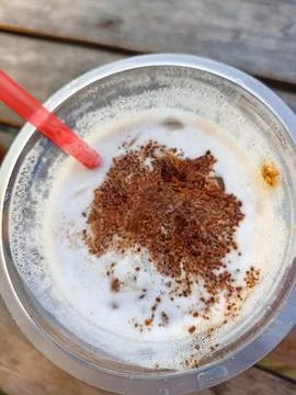 Close-up view of cold coffee drink with latte art sprinkles in a plastic cup wit Stock Photos