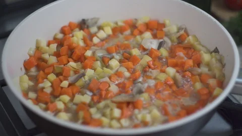 Close up view of colorful boiling vegetables with mushrooms frying in a pan mixe Stock Footage 107555199
