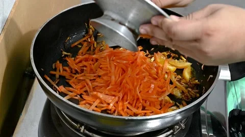 Close up view of colorful steaming carrots and vegetables frying on a pan be Stock Footage 218344779