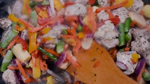 Close up view of colorful steaming vegetables frying on a pan being mixed. Stock Footage 119918576