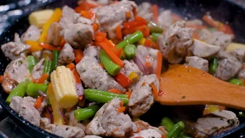 Close up view colorful steaming vegetables frying on pan being mixed. Side view Видео 119918587