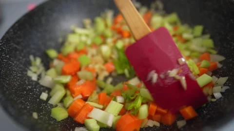 Close up view of colorful steaming vegetables frying on a pan being mixed and Vídeo Stock 150208116