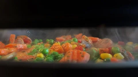 Close up view of colorful steaming vegetables frying on a pan. Carrots, peas Video stock 272825879