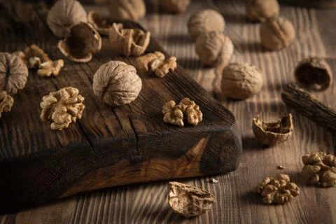 Close up view composition of walnut kernels and whole walnuts on rustic cutin Stock Photos
