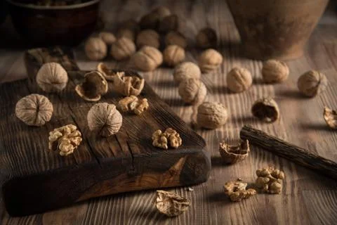 Close up view composition of walnut kernels and whole walnuts on rustic cutin Stock Photos