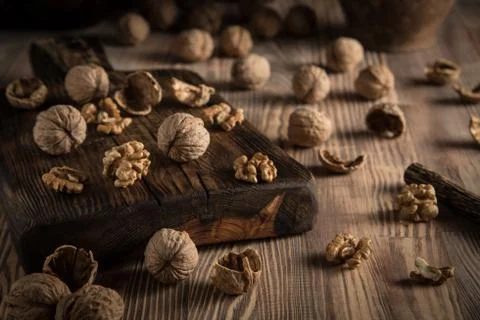 Close up view composition of walnut kernels and whole walnuts on rustic cutin Stock Photos