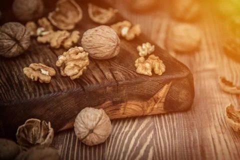 Close up view composition of walnut kernels and whole walnuts on rustic cutin Stock Photos