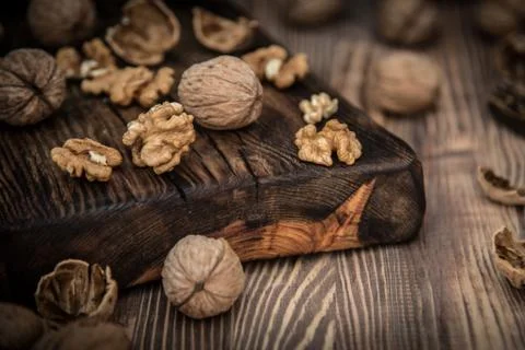 Close up view composition of walnut kernels and whole walnuts on rustic cutin Foto stock