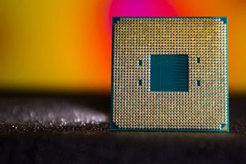 Close view of a computer processor placed on a dark surface with colorful lights 库存照片