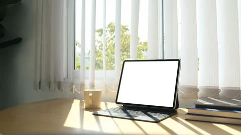 Close up view of computer tablet, coffee cup and books beside the window with Stock Photos