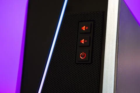 Close view of a computer tower with power and sound buttons lit up during a Stock Photos