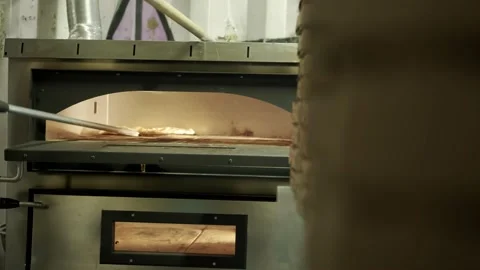 Close up view of cook putting pizza in electric oven in a restaurant, Stock Footage 160992329