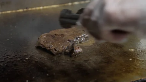 Close view cook turns frying meat in sauce with tongs Stock Footage 104841465