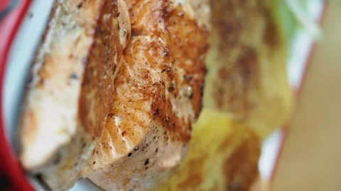 Close up view of cooked salmon fillets with crispy golden skin on plate mot.. Vídeos de archivo 332029525