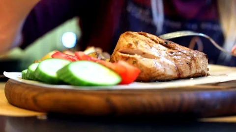 Close-up view of cooked tasty red grill meat with sliced vegetables on wooden ro 스톡 동영상 117668160