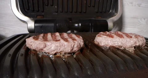 Close up view of cooking meat on electric grill Stock Footage 165992746