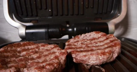 Close up view of cooking meat on electric grill Stock Footage 165992802