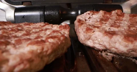Close up view of cooking meat on electric grill Stock Footage 166512544