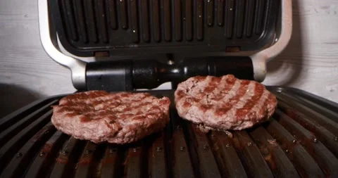 Close up view of cooking meat on electric grill Stock Footage 166823560