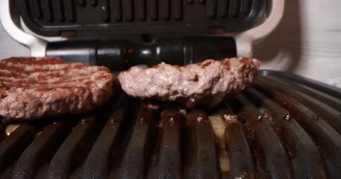 Close up view of cooking meat on electric grill Stock Footage 168060632