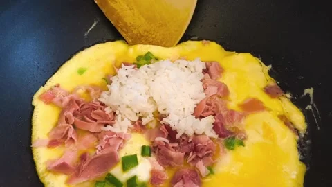 Close-up view of cooking an omelette as ham and sliced green onion egg in pan Video stock 318130130