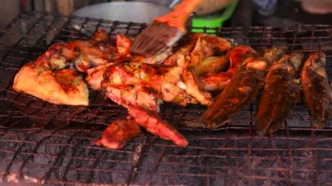 Close up view of cooking spicy Thai style chicken and fish. grilled on coal.. Video stock 324935992