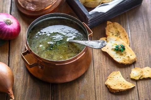Close view of copper pot with onion soup and croutons Stock Photos
