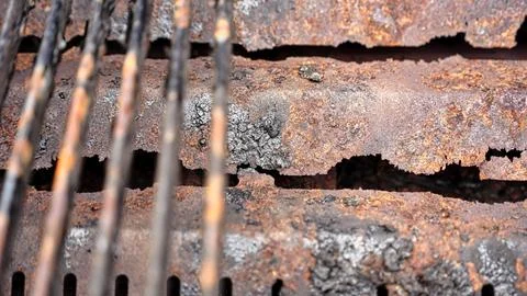Close-up view of a corroded metal surface and rusty grill grates Stock Photos