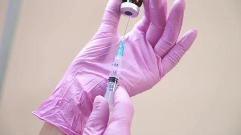 Close-up view on a cosmetologists hands in gloves holding syringe with needle fo Video stock 82891593
