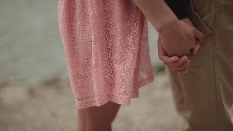 Close up view of a couple holding hands by the lake shore, lovers embrace, kiss  Video stock 71775879