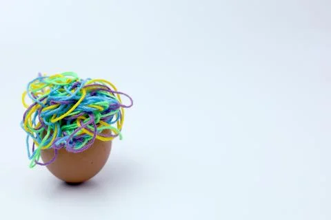 Close-up view cracked eggshell on white background with colorful tangled th.. 스톡 사진