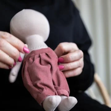 Close-up view on the creative process of sewing doll, details of doll cloth Stock Photos