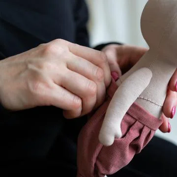 Close-up view on the creative process of sewing doll, details of doll cloth Stock Photos