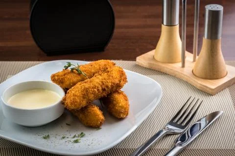 Close up view of crispy deep fried fish fingers with breadcrumbs served with Stock Photos
