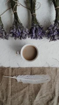 Close-up view of the cup of coffee surrounded by little bouquets of dry lavender Stock Photos