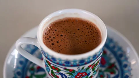 A close up view of a cup of turkish coffee with a frothy top, served in a t.. Stock Footage 339666319