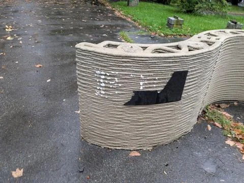 Close view of a curved 3D-printed concrete wall with layered extrusion texture Stock Photos