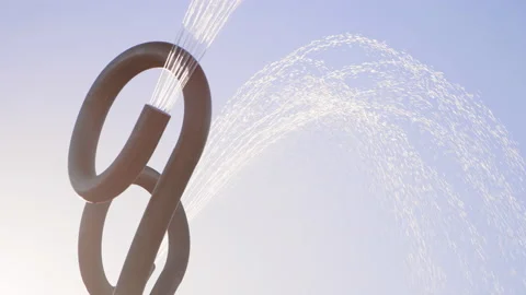 Close view of curved circular water spraying features at splash pad, slow motion 스톡 동영상 233944510