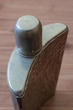 Close view of curved silver flask with top in place, drinking alcoholism Stock Photos