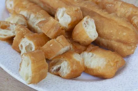 Close up view of cut cakoi or youtiao cake on white plate. Asian food concept Stock Photos