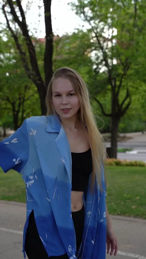 Close-up view of cute beautiful blonde girl in a walking along the evening .. Stock Footage 265003365