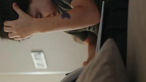 Close up view of cute boy taking notes in notepad while sitting on comfortable Video stock 265132718