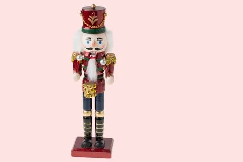 Close up view of cute Nutcracker figure on pink background. Stock Photos