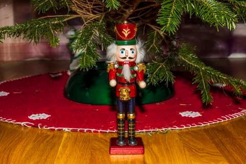 Close up view of cute Nutcracker figure with green Christmas tree. Stock Photos